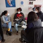 Mujeres sentadas en reunión mirándose entre si