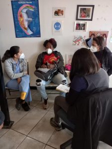 Mujeres sentadas en reunión mirándose entre si